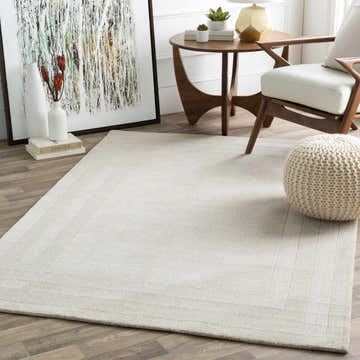 Living room scene with a beige Ferrum Area Rug, wood furniture, and abstract art. Roomscene-Rectangle