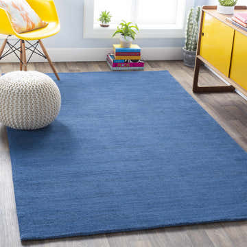 Bright living room scene with a solid blue Brockton wool rug, yellow chair, and modern decor. Roomscene-Rectangle