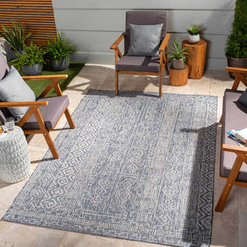 Outdoor patio scene with wood chairs and blue Epson Indoor Outdoor Rug. Roomscene-Rectangle