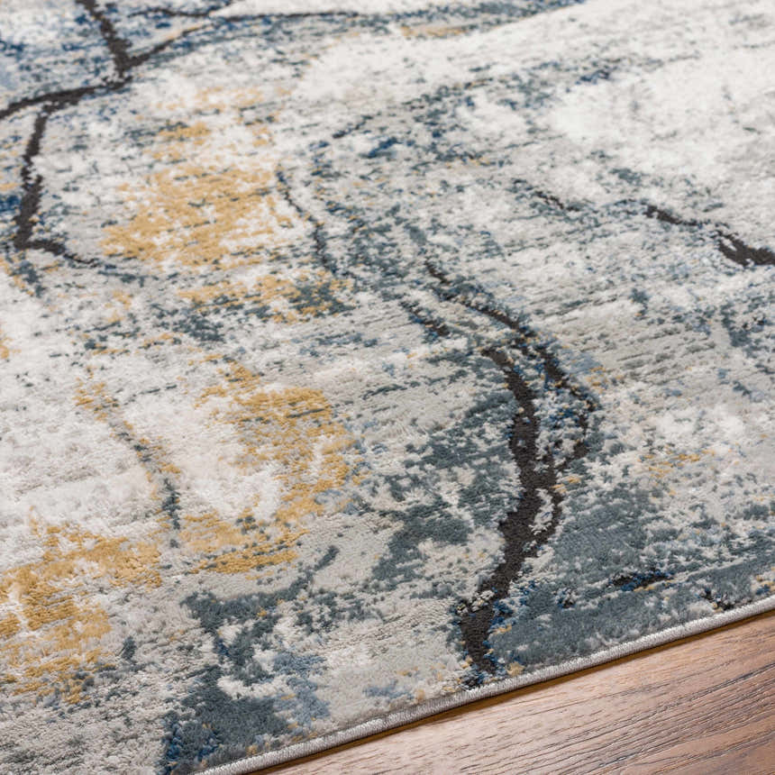 Close-up of the Fremantle Gray Marble Rug. Cream, dark gray, gold, light blue and gray abstract pattern. Texture