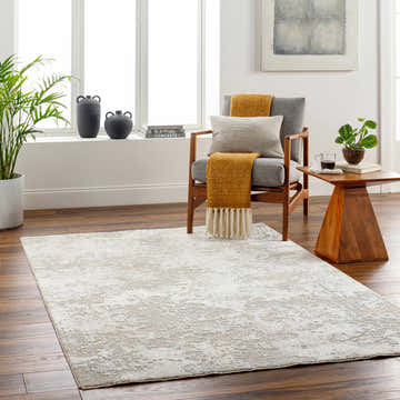 Living room scene with a beige Ganit Thick Luxe Boutique Rug, gray chair, and wood accents. Roomscene-Rectangle