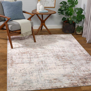 Living room scene with a Gerona Abstract Area Rug in charcoal, gray, and brown tones, styled with a mid-century modern chair and wood side table. Roomscene-Rectangle