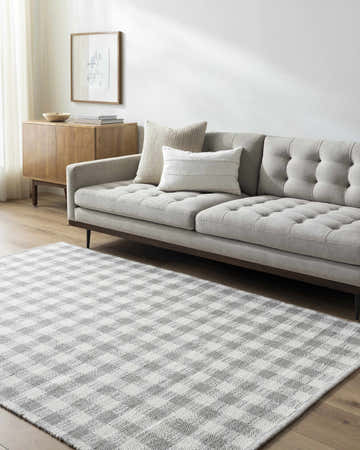 Living room scene with a gray sofa and the Garth Ivory Wool Rug featuring a gray and white checkered pattern. Roomscene-Rectangle