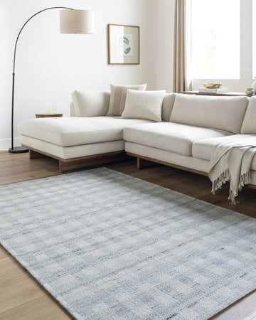 Living room scene with a light slate Garth area rug, ivory sectional sofa, and wood floors. Roomscene-Rectangle