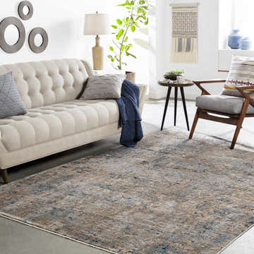 Living room scene with a Gorokan area rug in cream, brown, and blue tones, complementing the beige sofa and modern decor. Roomscene-Rectangle