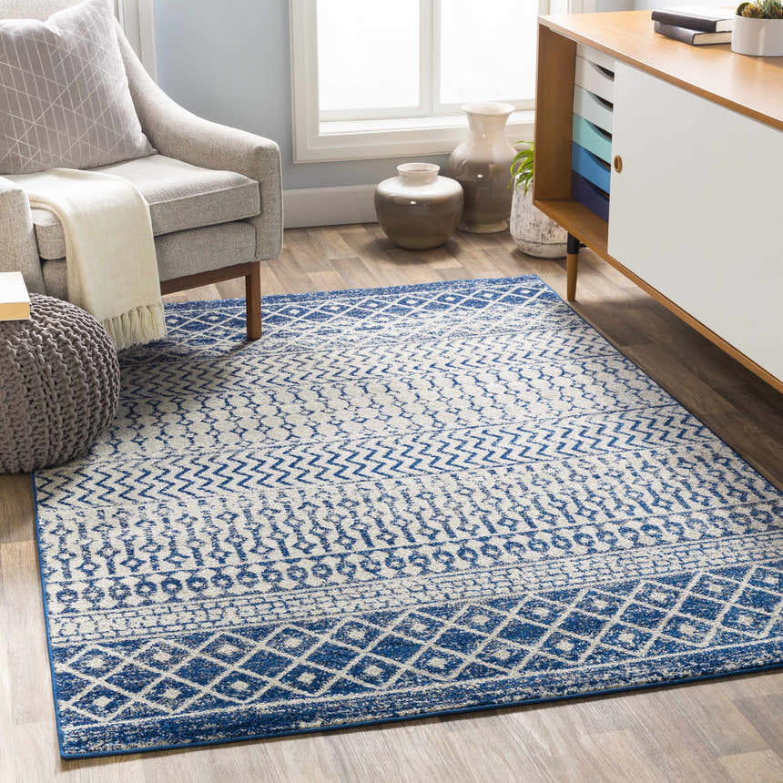 Living room scene with a blue and white Constantin Area Rug, gray chair, and modern cabinet. Roomscene-Rectangle