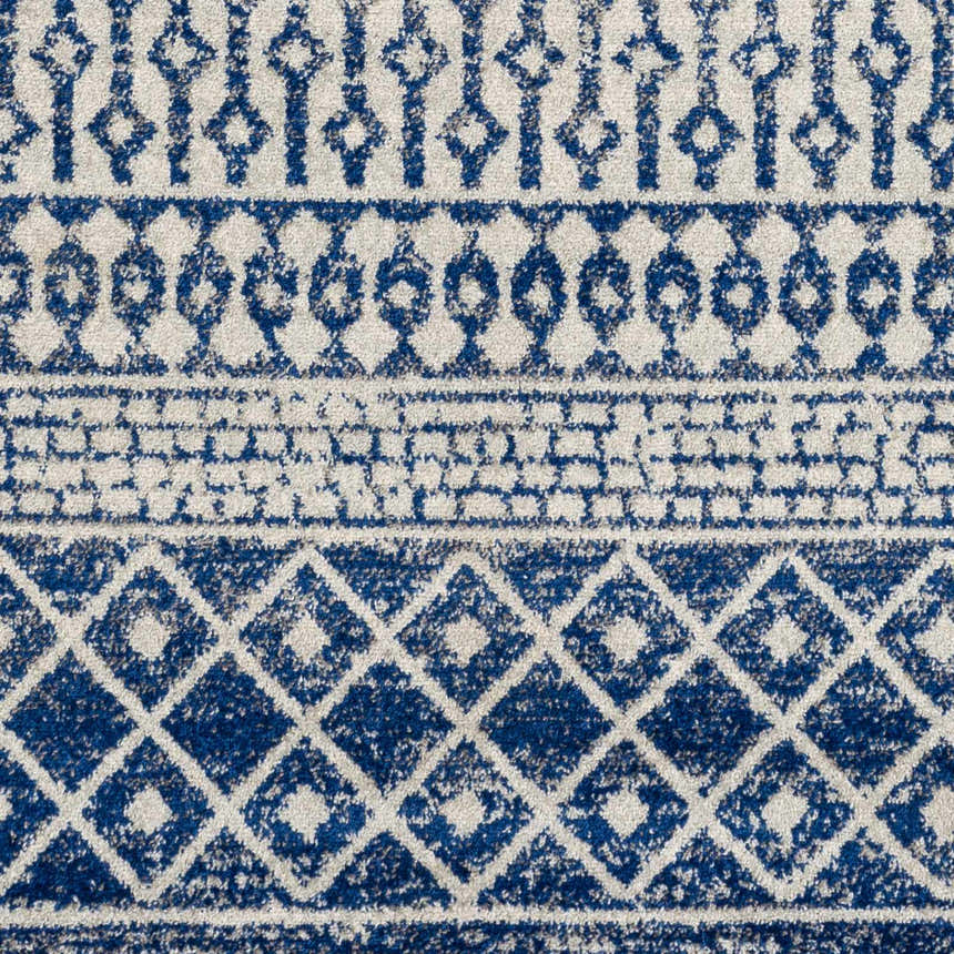 Close-up of the Constantin Blue Area Rug. Features a bohemian-inspired geometric pattern in shades of blue, gray, and white. Texture