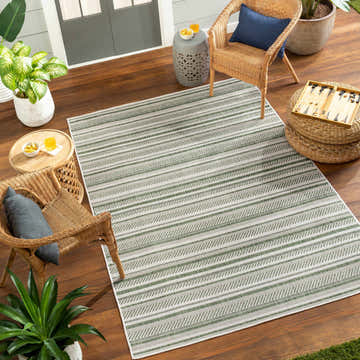 Outdoor patio scene with a Gram Striped Nordic Rug, wicker chairs, plants, and wood flooring creating a relaxing space. Roomscene-Rectangle
