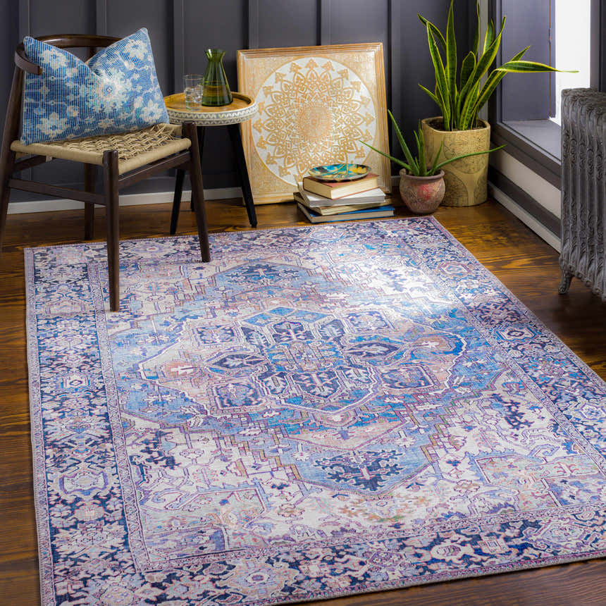Cozy room scene with the Neyland Iris Blue Area Rug, chair, side table, plants, and dark blue accent wall. Roomscene-Rectangle