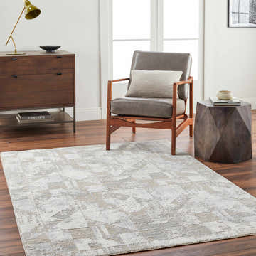Living room scene with a gray chair and the Halia Thick Luxe Boutique Rug in cloud gray and brown tones. Roomscene-Rectangle