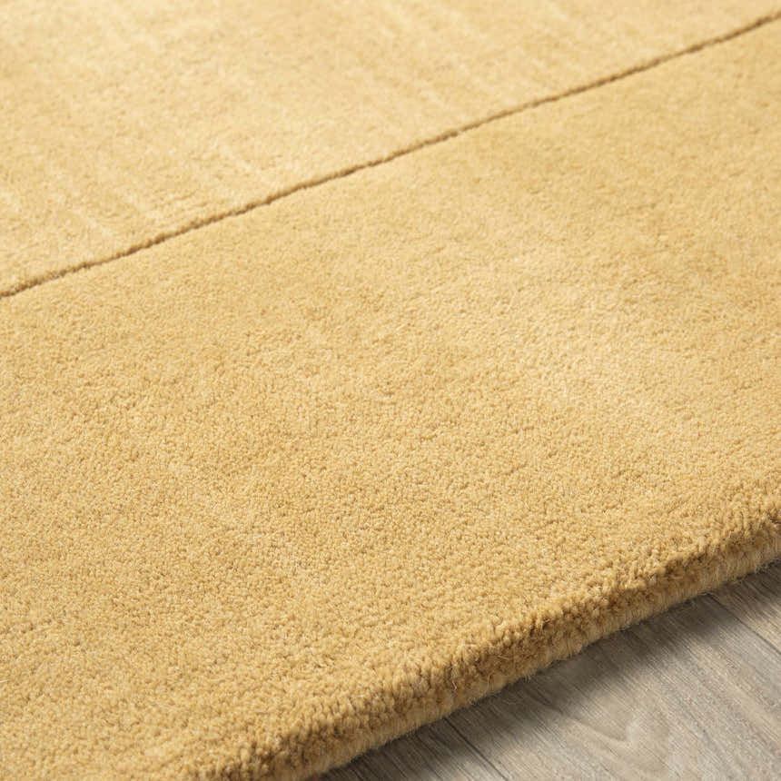 Close up of the hand-loomed Bordered Solid Camel Yellow Wool Rug showing texture and border detail. Texture