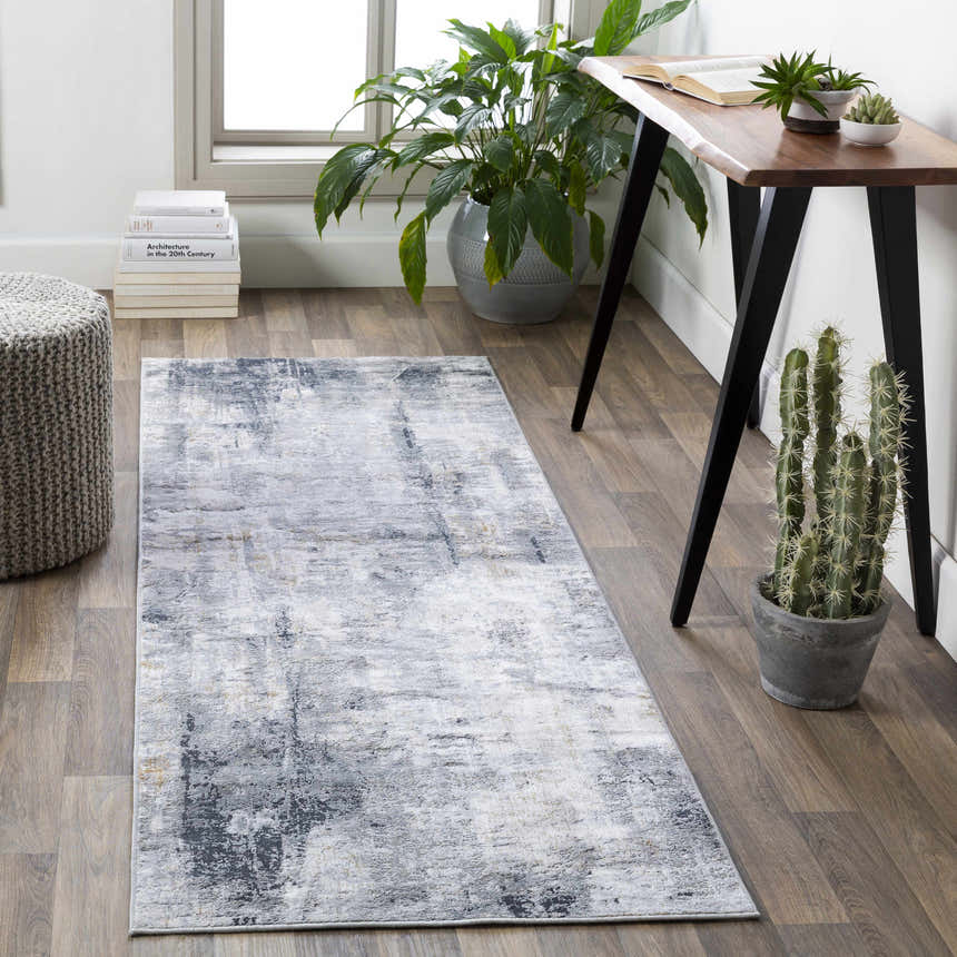 Home office with gray Hayle Area Rug, wood desk, plants, and woven ottoman for a contemporary style. Roomscene-Runner