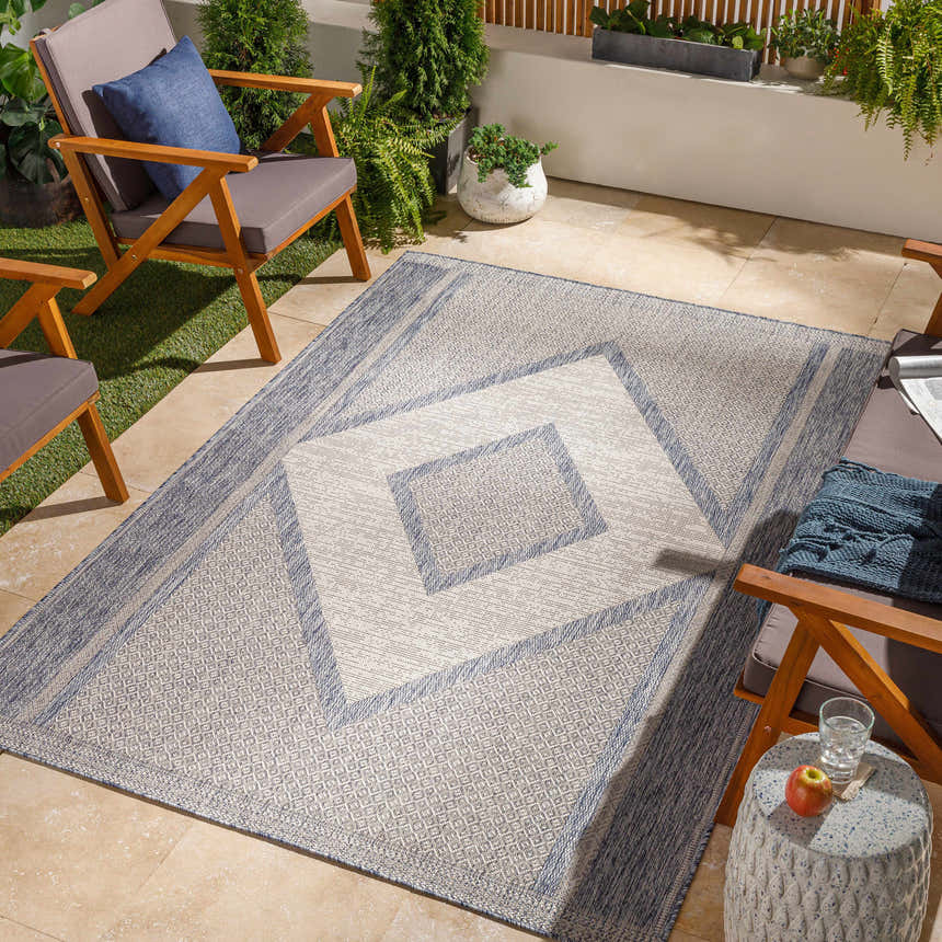 Outdoor patio scene with gray cushioned chairs and a Hazar Gray Area Rug featuring a geometric diamond pattern. Roomscene-Rectangle