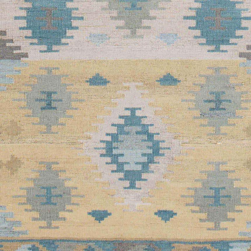 Close-up of the hand woven Heth Carpet. Beige, blue, and charcoal geometric pattern on 100% wool. Farmhouse style. Swatch