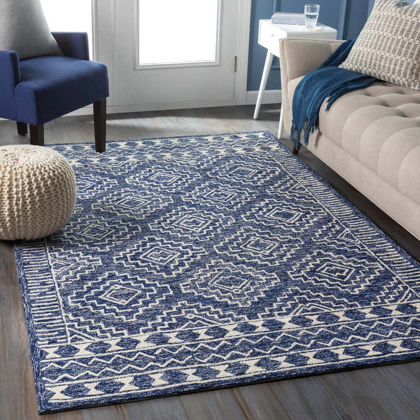 Living room scene with a navy and beige Horton Modern Wool Rug, blue chair, and beige sofa. Roomscene-Rectangle