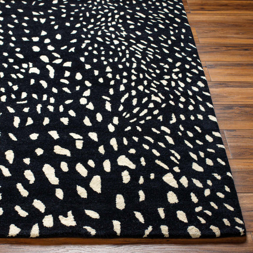 Close-up of the Athena Black Giraffe Print Wool Rug showing its black and beige animal-inspired pattern and hand-tufted texture. Front