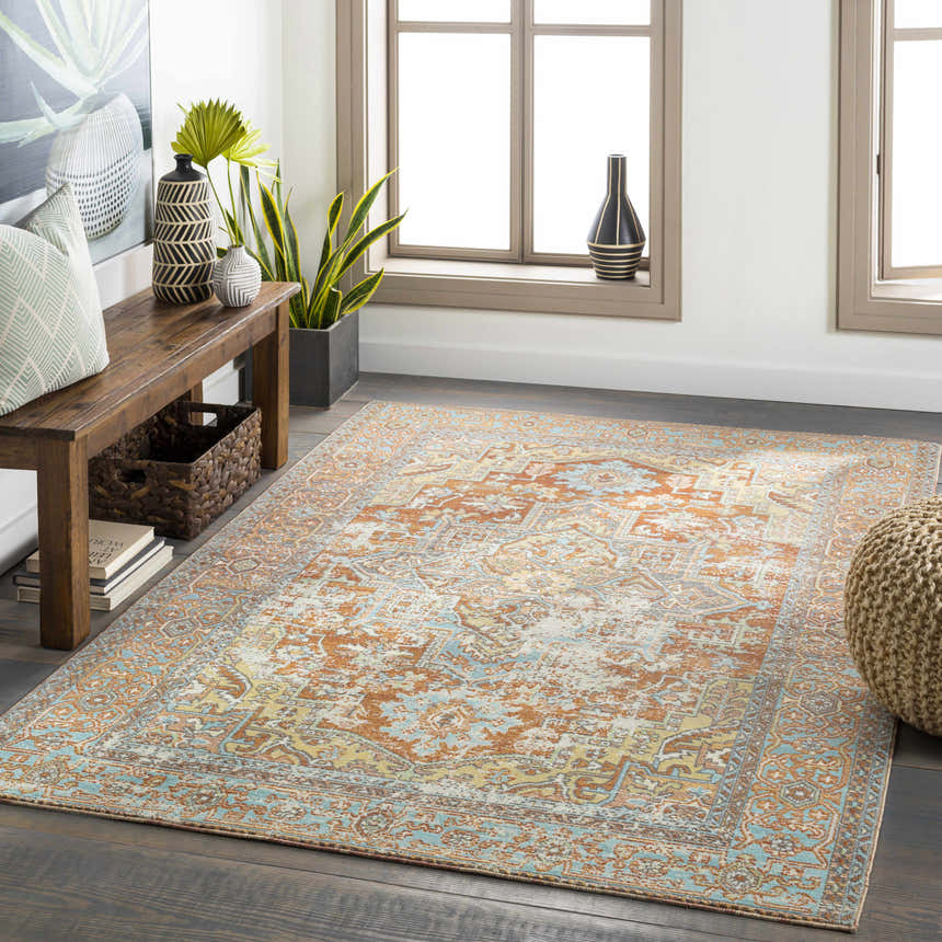 Living room scene with a brick red and blue Hardwick Performance Rug, wood bench, and natural light. Roomscene-Rectangle
