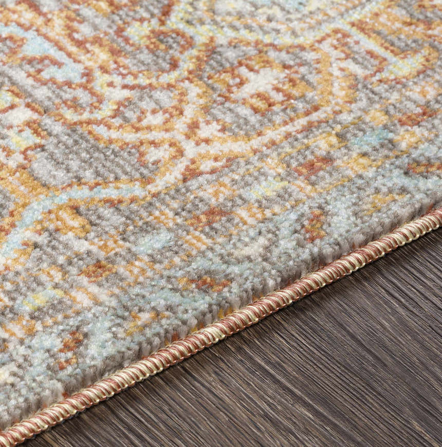 Close-up of the Hardwick Performance Rug showing its brick red, blue, and saffron bohemian pattern and textured weave. Texture