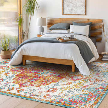 Bedroom scene with a Hosking Area Rug, featuring burgundy, orange, and teal hues, adding a bohemian touch to the light and airy space. Roomscene-Rectangle