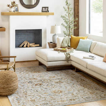 Living room scene with a cream sectional and the Huguley Floral Cream Luxe Rug. The rug features brick red, denim, and mustard accents. Roomscene-Rectangle