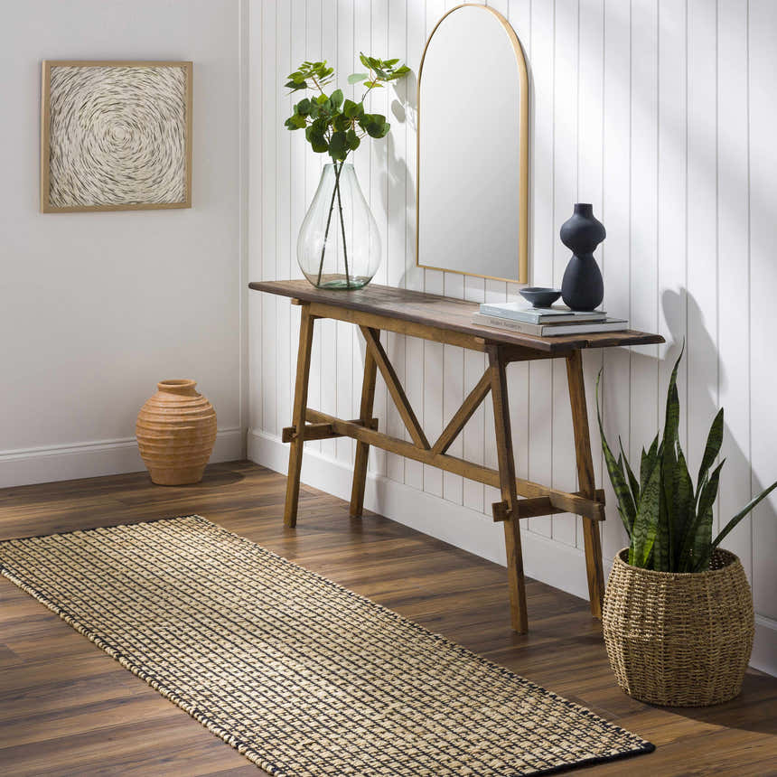 Entryway scene with Iqaluit Natural Jute Rug, wood console table, mirror, plants, and neutral decor. Roomscene-Runner