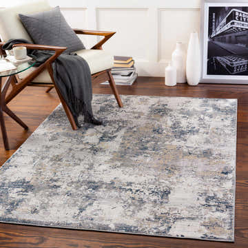 Living room scene with Islington Textured Luxe Area Rug in charcoal, blue, beige, and gray. Modern chair, wood floors, and neutral decor. Roomscene-Rectangle