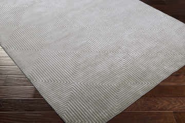 Close-up of the Ivel Carpet, a gray and light gray hand-knotted rug with a contemporary geometric square pattern. Corner