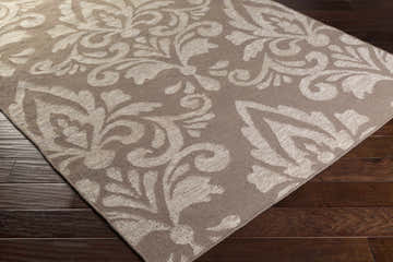 Close up of the taupe and light gray Ivybridge Area Carpet with a traditional floral pattern. Corner