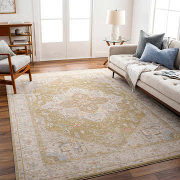Living room scene with a Jago Thick Luxe Area Rug in amber and olive tones, styled with a beige sofa and wood accents. Roomscene-Rectangle