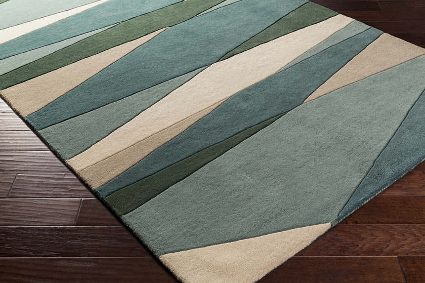 Close-up of the Jarratt Modern Wool Rug featuring a geometric pattern in cream, sage, teal, and green hues. Corner