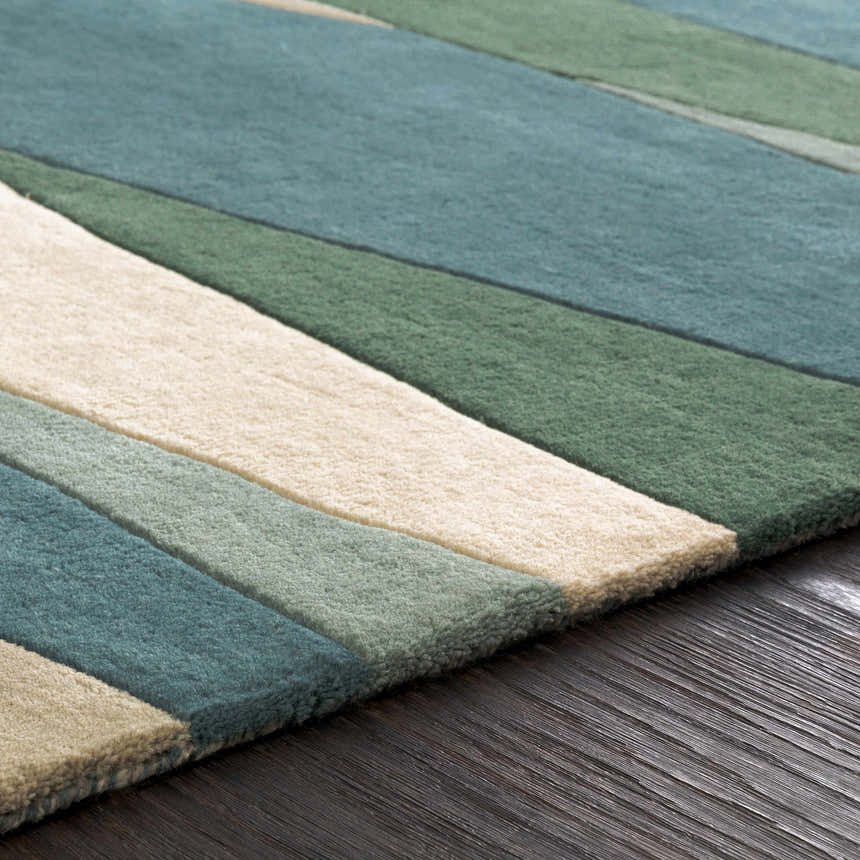 Close up of the Jarratt Modern Wool Rug showing cream, green and teal stripes on a dark wood floor. Texture