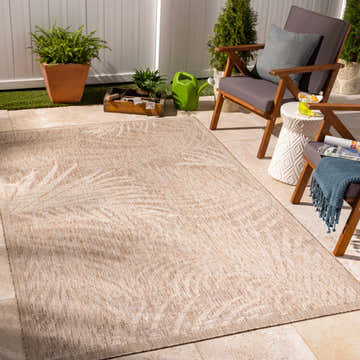 Outdoor patio scene with Jens Area Rug, wooden chairs, and potted plants creating a cozy, coastal vibe. Roomscene-Rectangle