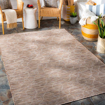 Cozy patio scene with a brown and cream Jerramungup Flatweave Area Carpet, wicker chairs, and colorful baskets. Roomscene-Rectangle