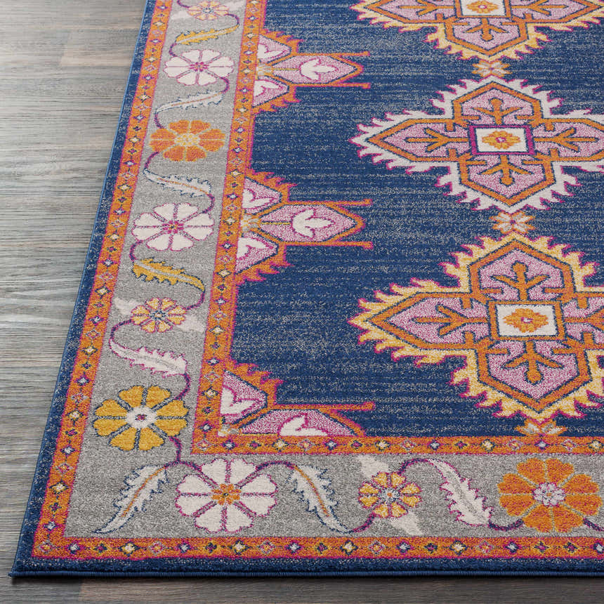 Close up of the Kaitlyn Navy Area Rug showcasing its bohemian floral border and geometric navy center. Front