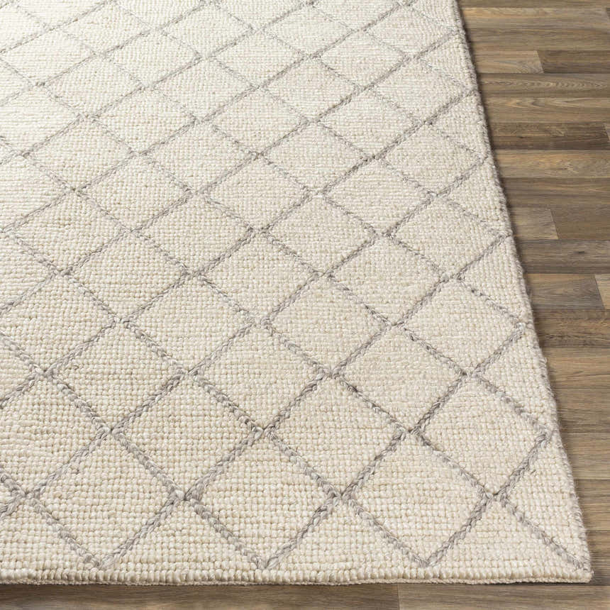 Close up of the Kanopolis Carpet, a hand woven rug with a cream and gray diamond pattern. Front