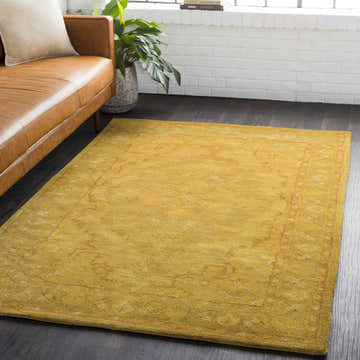 Living room scene with a mustard yellow Kapowsin Wool Area Rug, brown leather sofa, and white brick wall. Roomscene-Rectangle