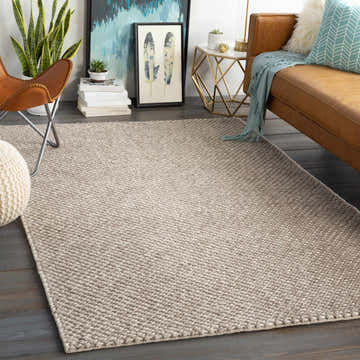 Living room scene with a charcoal and cream Keldron Clearance Rug, leather couch, and butterfly chair. Roomscene-Rectangle