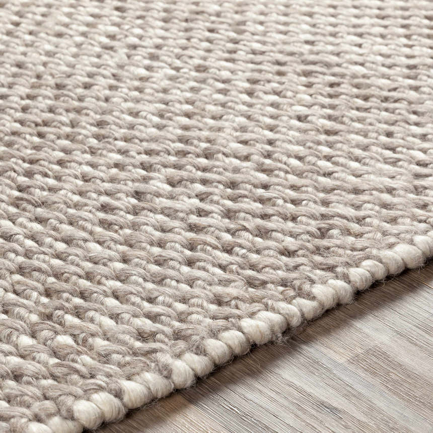 Close-up of the hand-woven Keldron Clearance Rug. Charcoal, cream, and dark brown wool and viscose texture. Texture