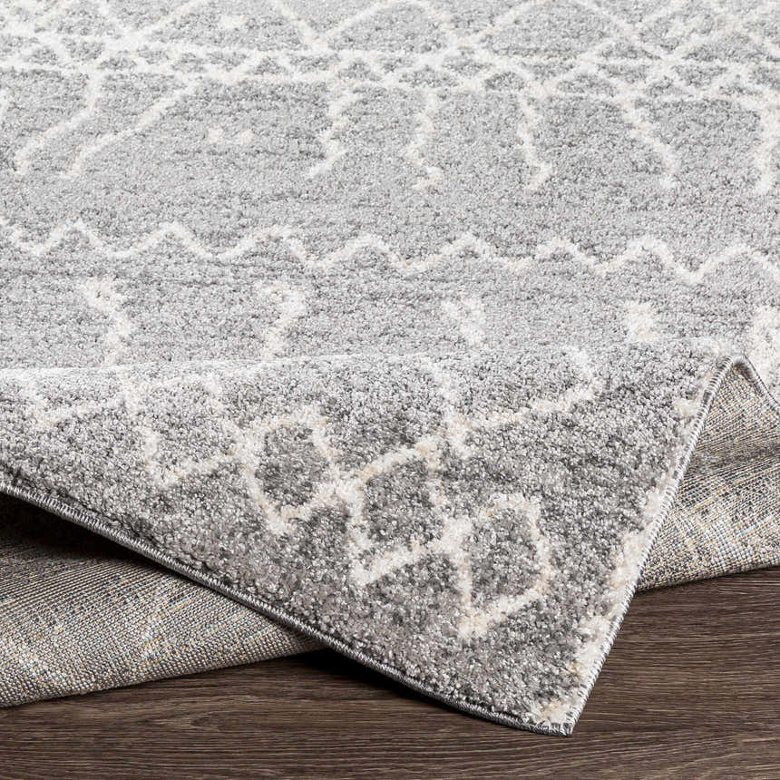 Close-up of the Kessingland Area Rug showing its gray and white geometric pattern and soft, textured pile. Fold
