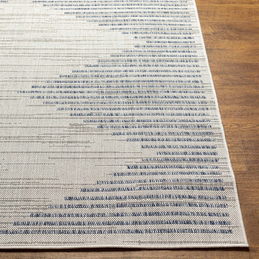 Close-up of the Khandallah Area Rug. Cream rug with dark gray and navy geometric stripe pattern. Machine woven texture. Front