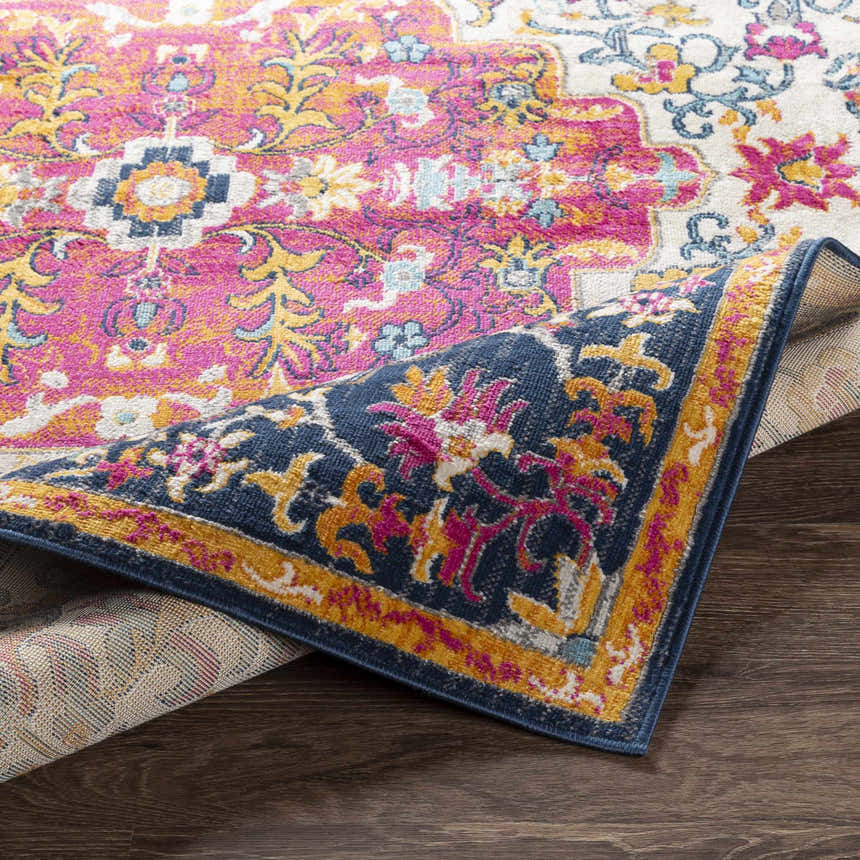 Close-up of the Kialla Magenta & Burnt Orange Area Rug showing the vibrant bohemian pattern and colors. Fold