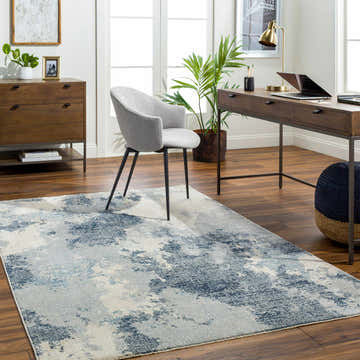 Home office with a Keme Area Rug in charcoal and silver, wood desk, gray chair, and wood floors. Roomscene-Rectangle