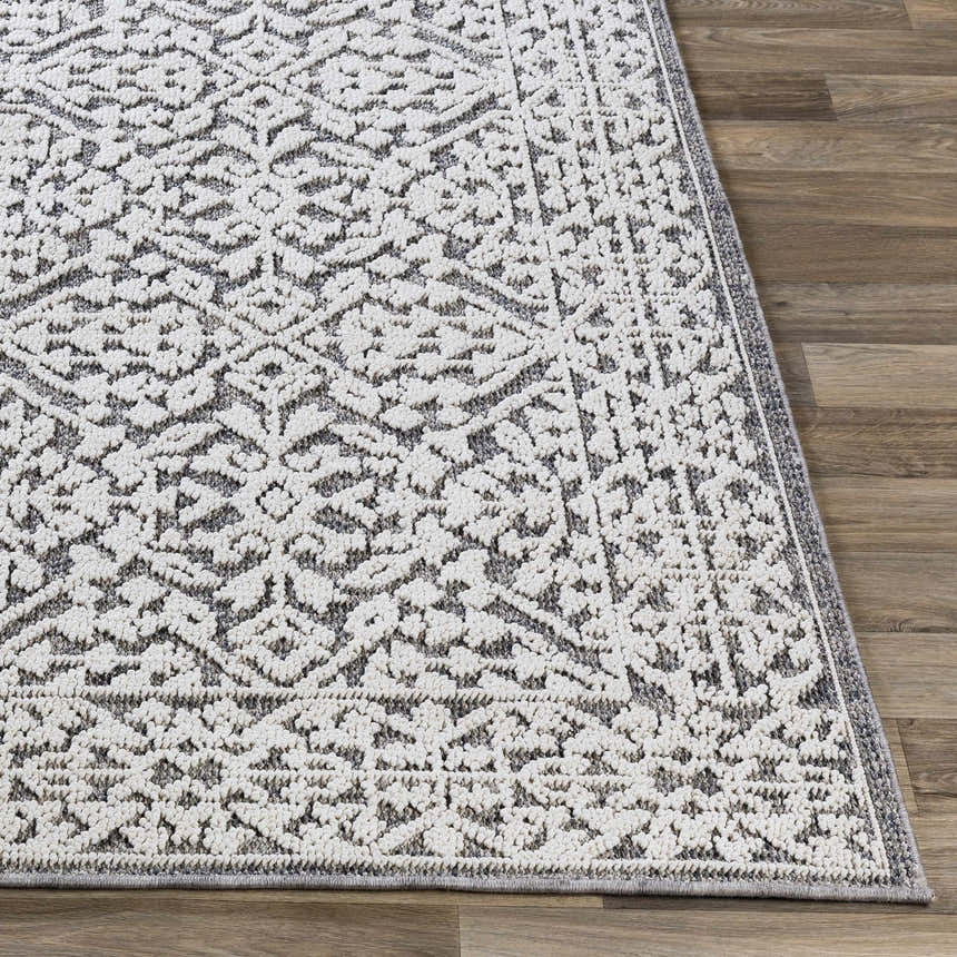 Close-up of the Kinglake Area Rug, a machine-woven rug with a geometric black, gray, and white pattern. Front