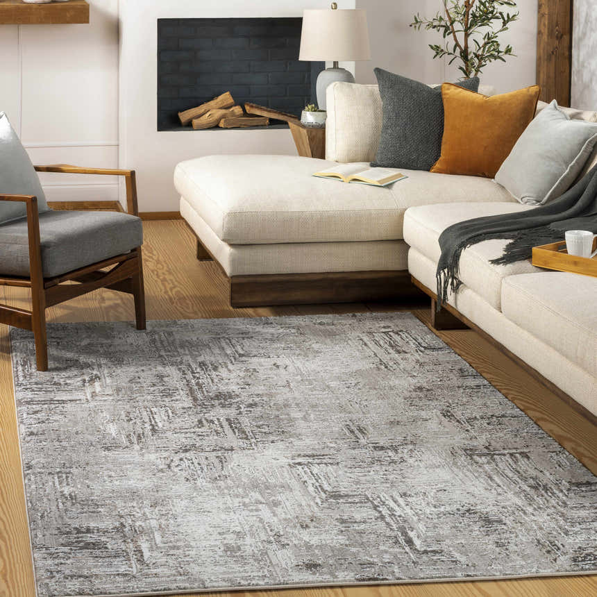 Living room scene with a Kutloanong area rug, cream sectional sofa, gray armchair, and fireplace. Roomscene-Rectangle