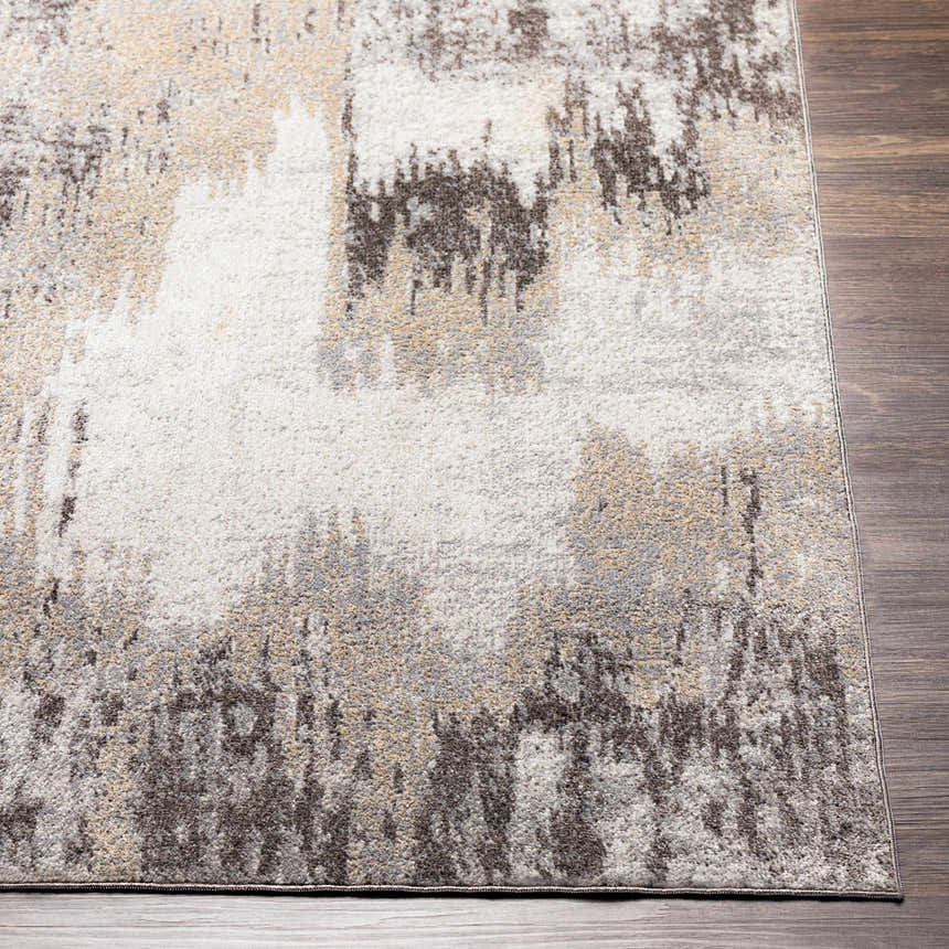 Close-up of the Kuyucak Washable Area Rug. Abstract design in brown, cream, gray, light beige, and taupe on a wood floor. Front
