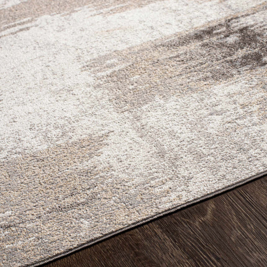Close-up of the Kuyucak Washable Area Rug. Abstract design in brown, cream, gray, and light beige. Soft, textured polyester. Texture