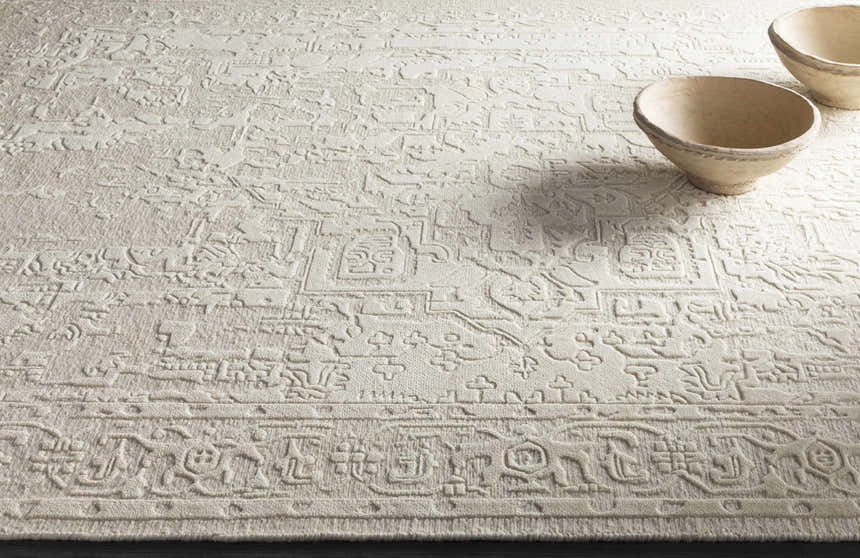 Close-up of the hand-knotted Larimer Area Rug. Cream wool rug with a raised, vintage-inspired geometric pattern. Styleshot