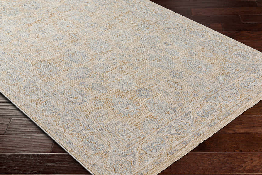 Close-up of the Coby Cream Avant Garde Rug showing its traditional pattern, brown, teal, and gray colors, and luxe texture. Corner