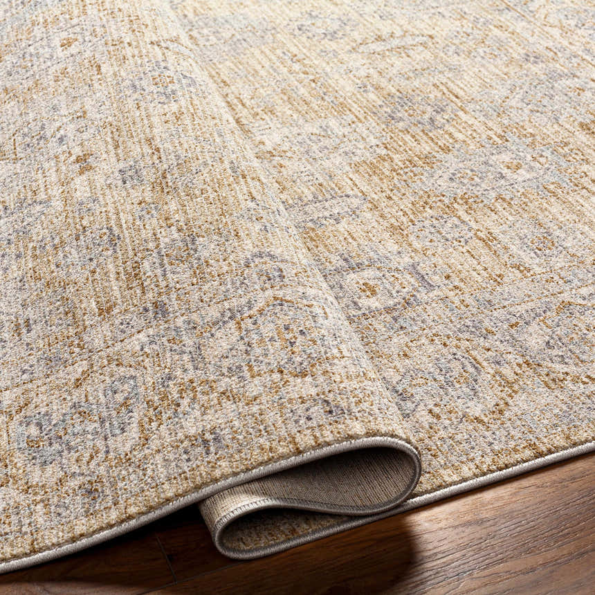 Close-up of the Coby Cream Avant Garde rug showing its brown, gray, and cream traditional pattern and thick, luxe texture. Fold