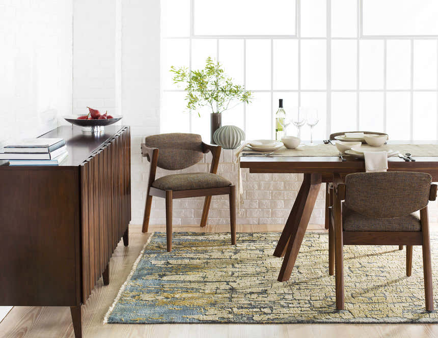 Dining room scene with a blue and olive Latour Carpet, wood table and chairs, and white brick wall. Roomscene-Rectangle